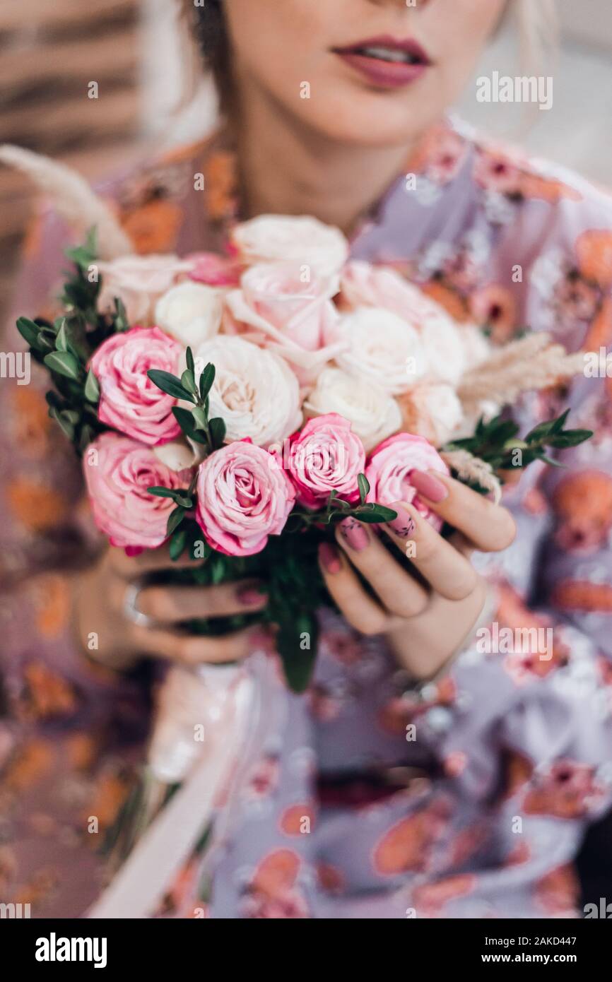 Hands of bride with wedding beautiful bouquet of white and pink roses. Stock Photo