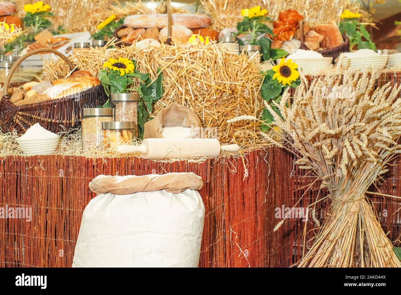 A variety of bakery products made from wheat flour.Spikelets of spinous wheat next to the dishes . Baking bread concept.Wheat flour in bags next to wh Stock Photo
