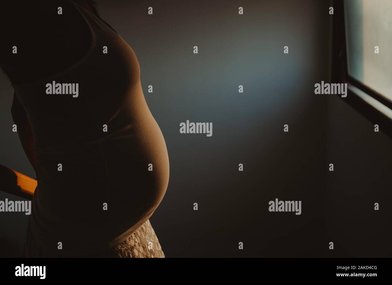 silhouette pregnancy women standing in a window,pregnancy belly Stock Photo