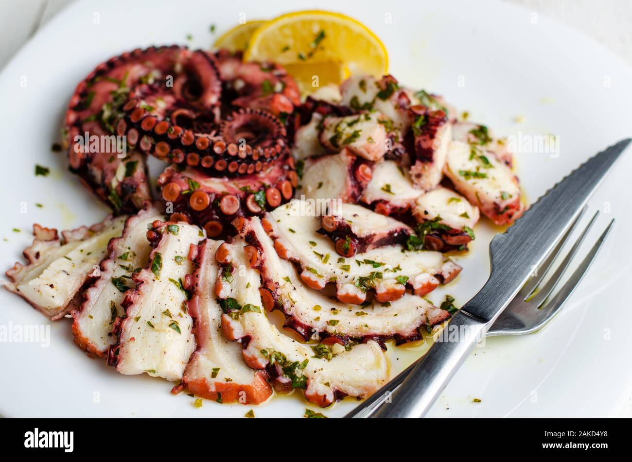 Seafood appetizer. Octopus Carpaccio on white plate. Mediterranean delicacy. Selective focus Stock Photo