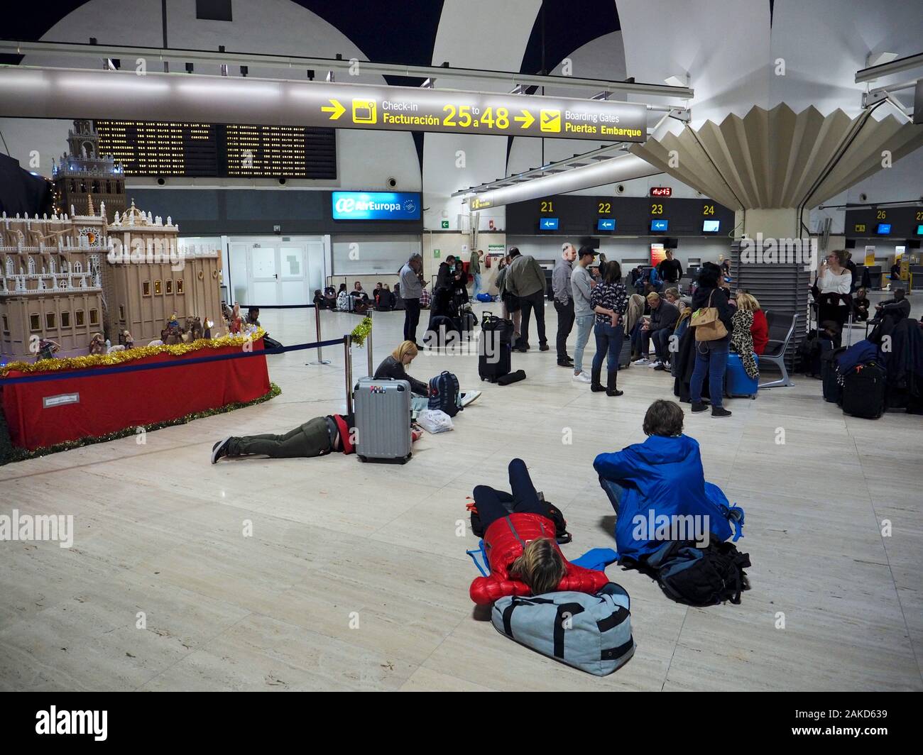 People waiting late at night on their delayed flight in the Sevilla airport terminal, Andalusia, Spain Stock Photo