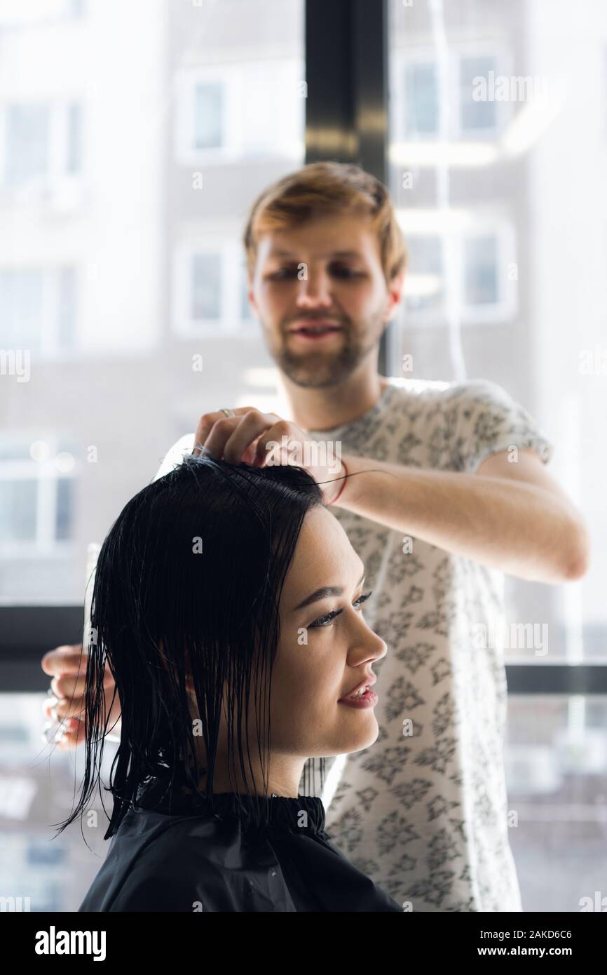 Hairdresser Working In Hair Salon Cutting Woman S Hair Stock Photo