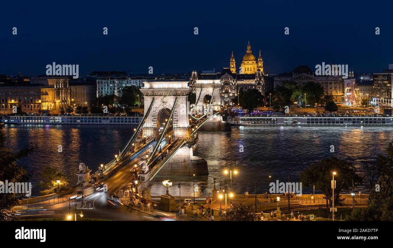 Night view of architectural landmarks Saint Stephens Basilica and Szechenyi Chain Bridge over the Danube River in Budapest, Hungary. Stock Photo