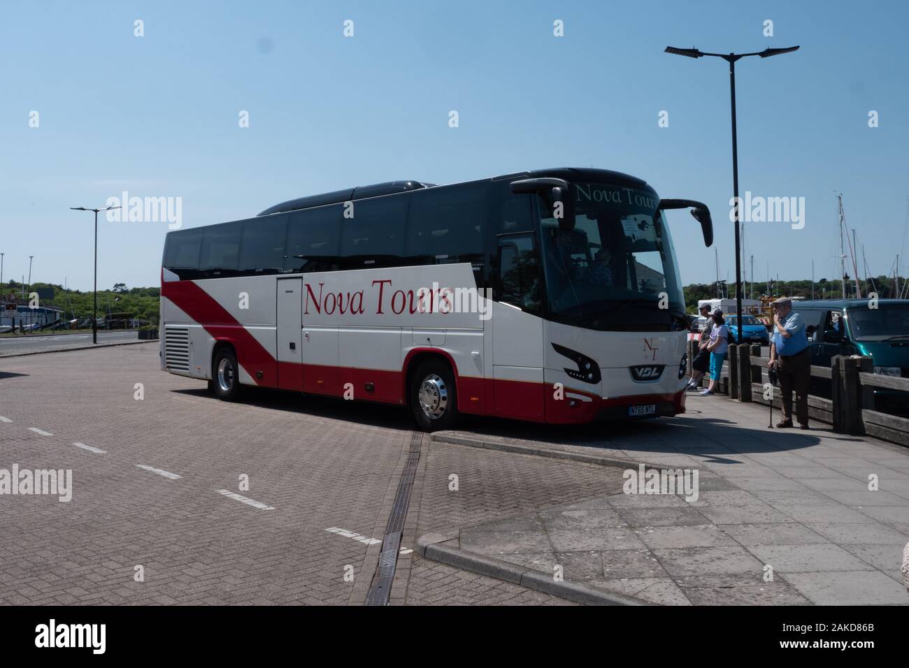 A VDL Futura coach of Nova Tours unloads passengers at Yarmouth Isle of Wight Stock Photo
