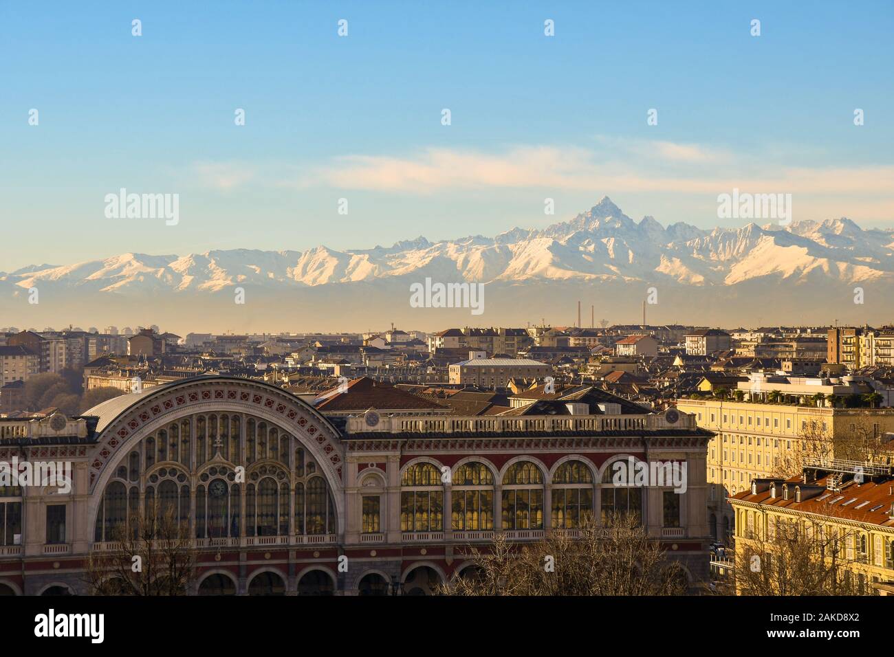 Rooftops view of Turin with the top of Porta Nuova train station and the Cottian Alps with Monviso peak in a sunny winter day, Piedmont, Italy Stock Photo