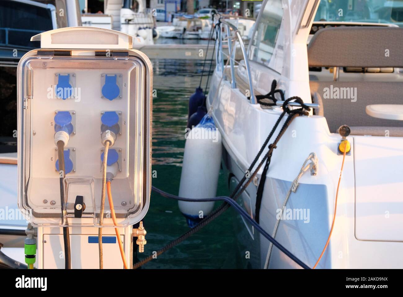 Electrical power sockets bollard on pier near sea coast. Charging