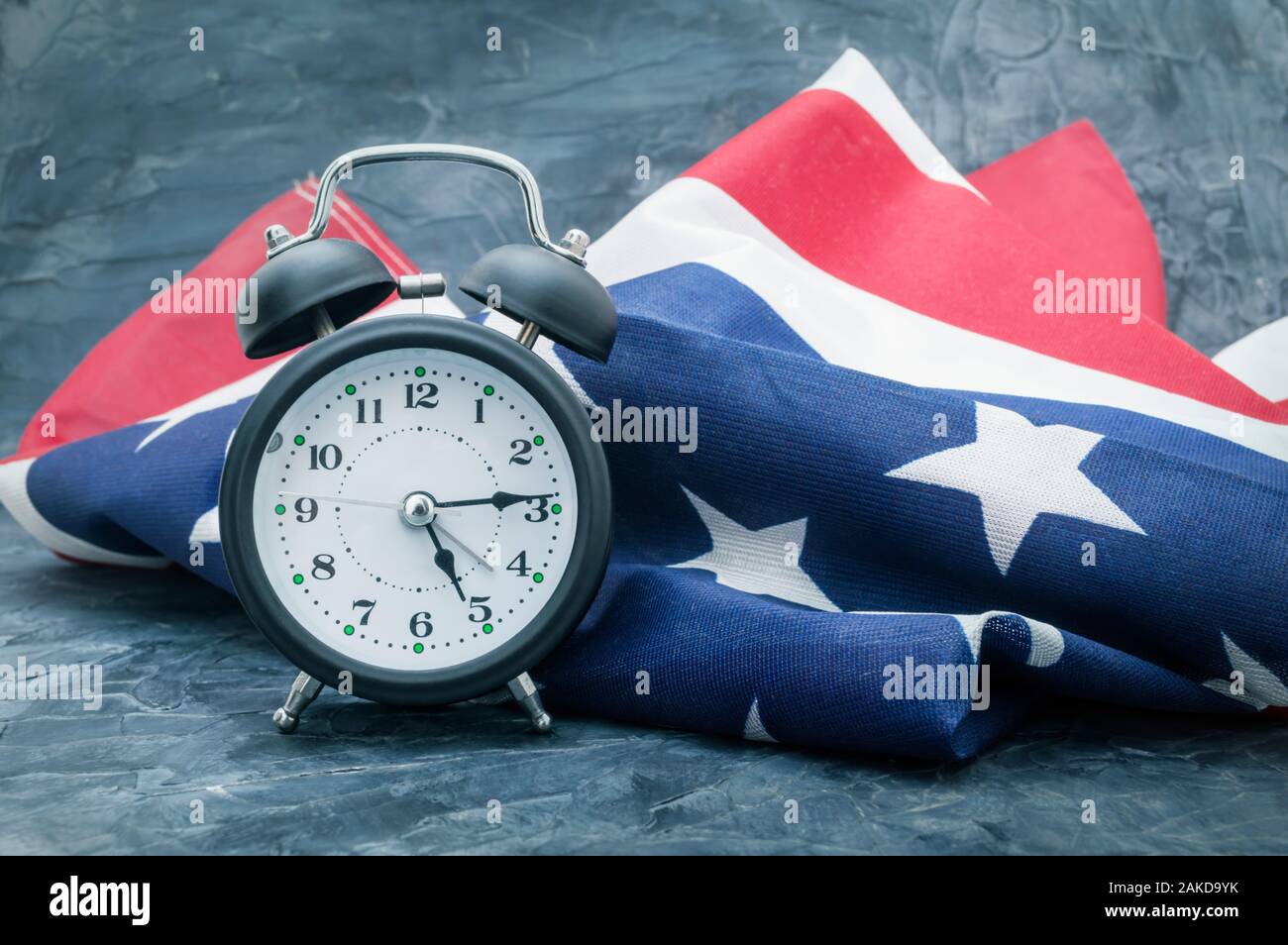 National flag of America and black alarm clock on dark background Stock Photo