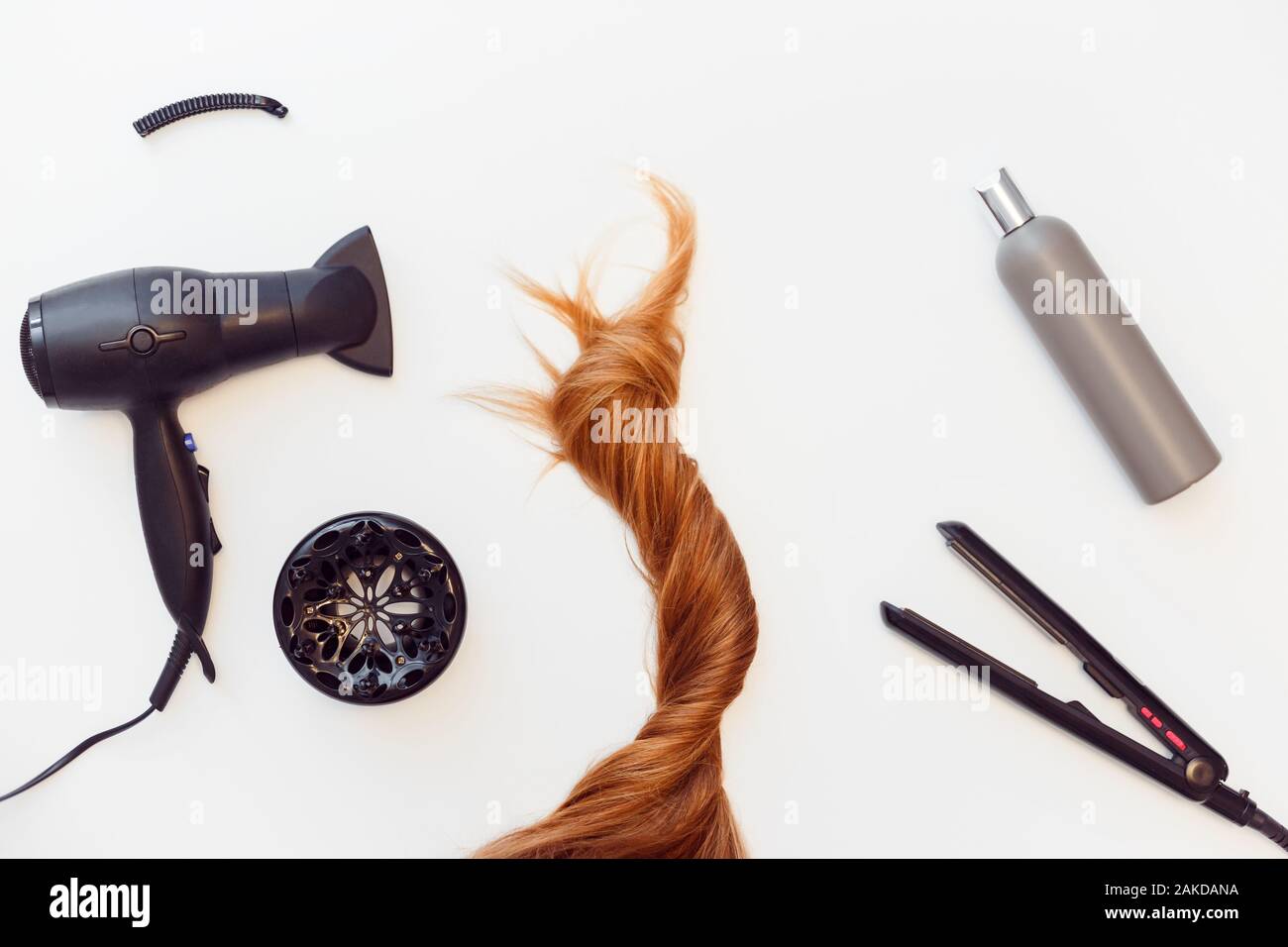 Set of tools dryer, iron and hair brush for hairstyle and red hair on white Stock Photo