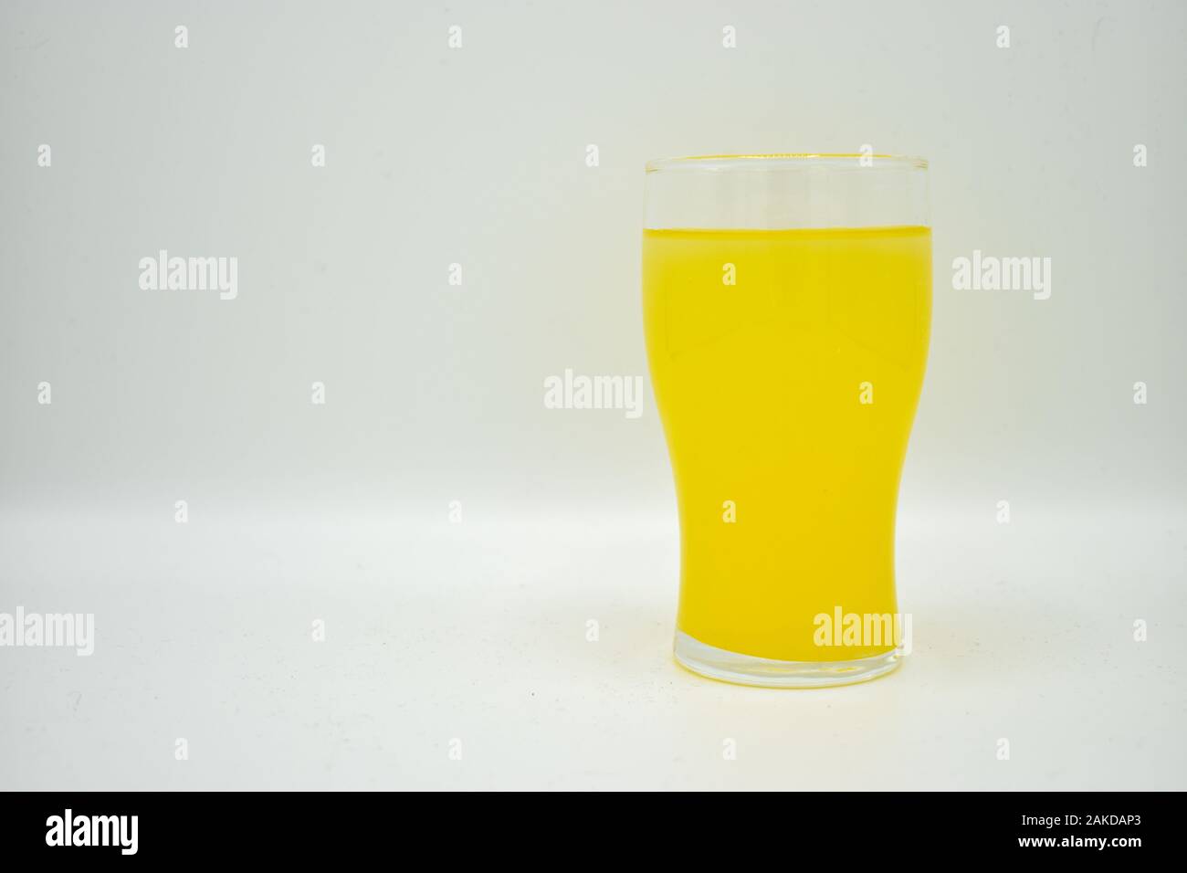 glass of orange fruit juice or squash isolated on white background
