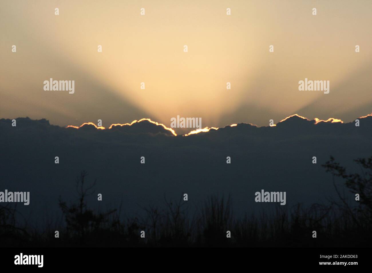 Sun rays emerging from behind a mass of clouds Stock Photo - Alamy