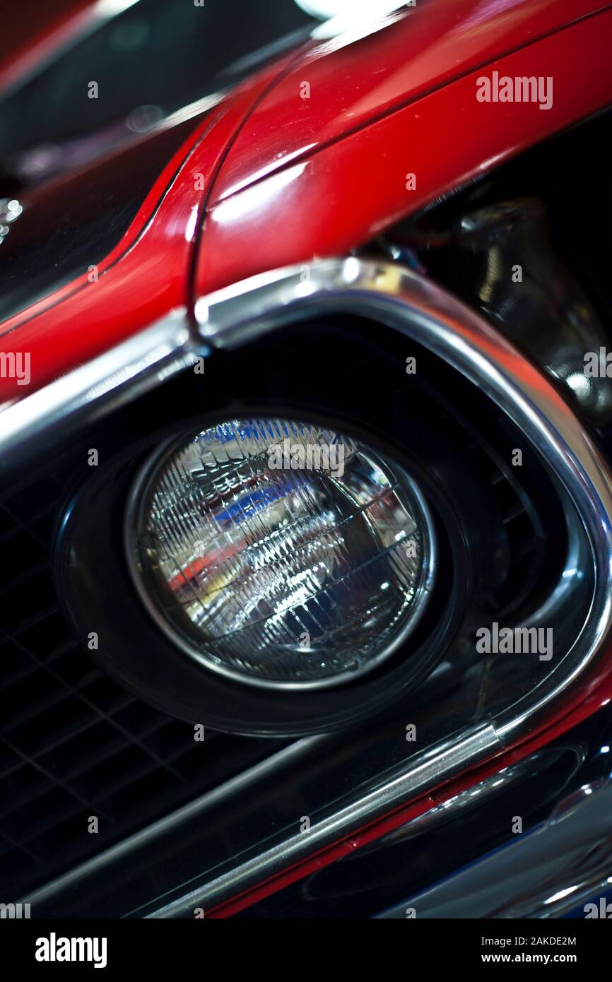 Front headlight detail on red American muscle car Stock Photo