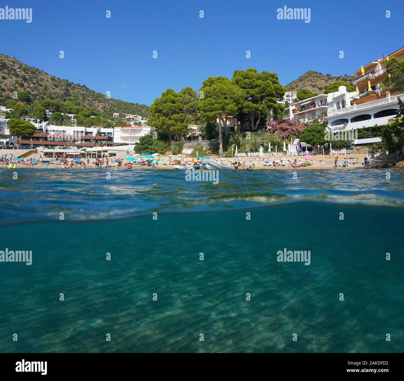 Mediterranean sea urban beach in summer in Spain on the Costa Brava with sand underwater, split view over and under water surface, Catalonia, Roses Stock Photo