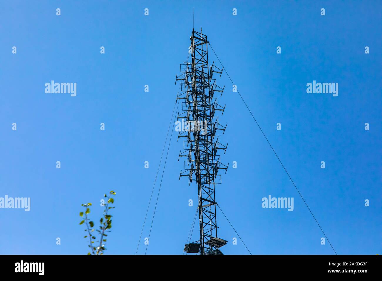 An antenna array is seen attached to a cable stayed steel lattice tower