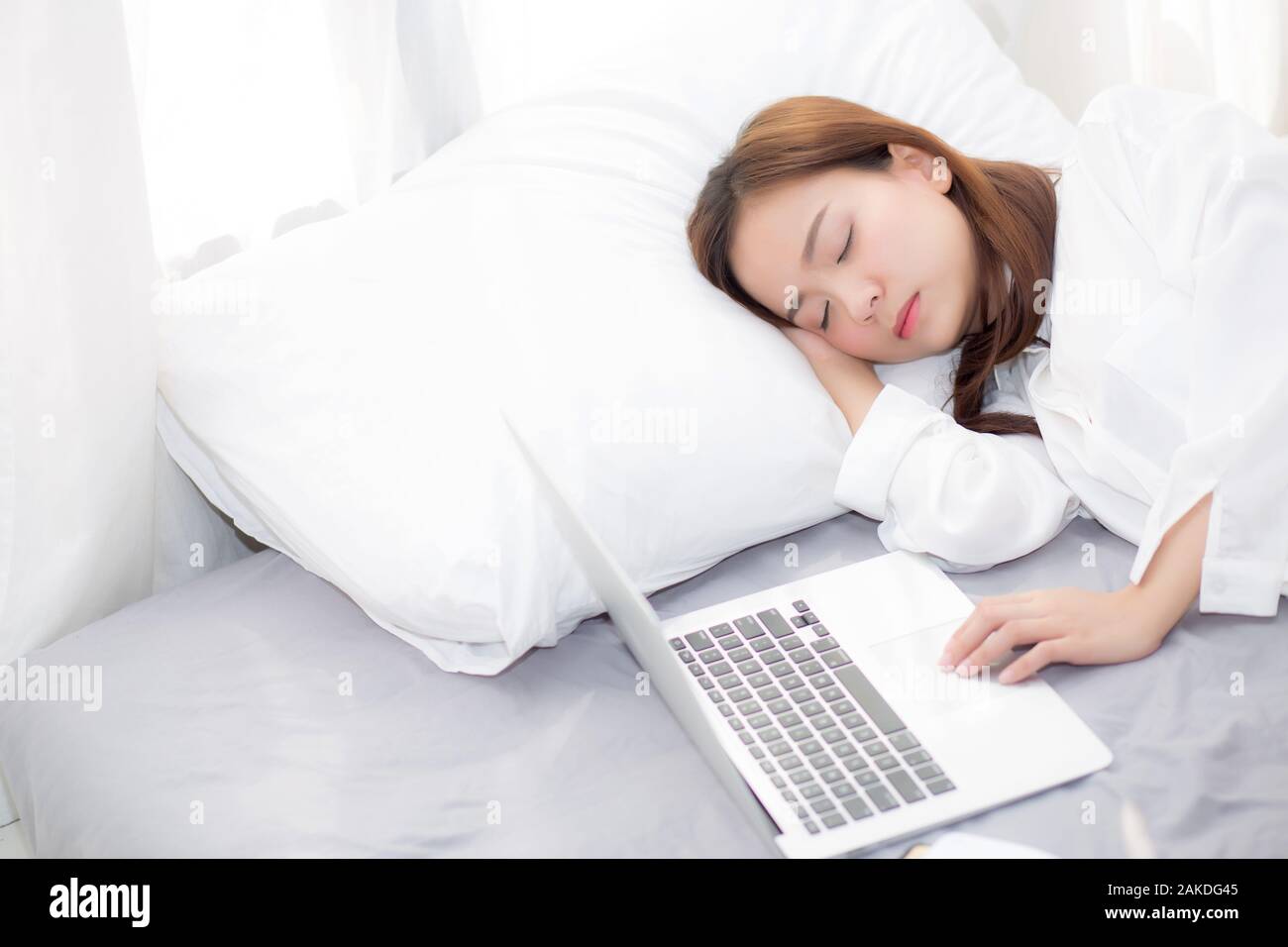 Beautiful Young Asian Woman With Laptop Lying Down In Bedroom