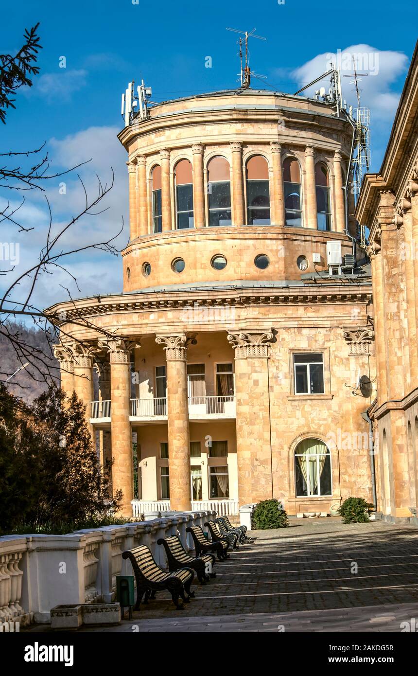 Corner of the building of the sanatorium 'Mountain Armenia' with balconies framed by bearing classical columns and top dome veranda in the forest of t Stock Photo