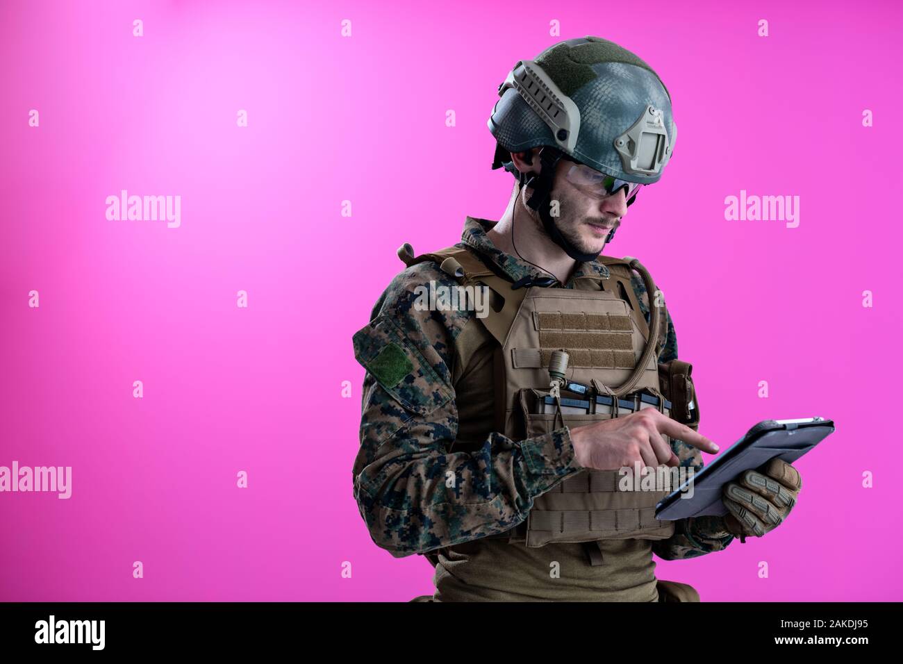 soldier using tablet computer hands closeup pnk background Stock Photo