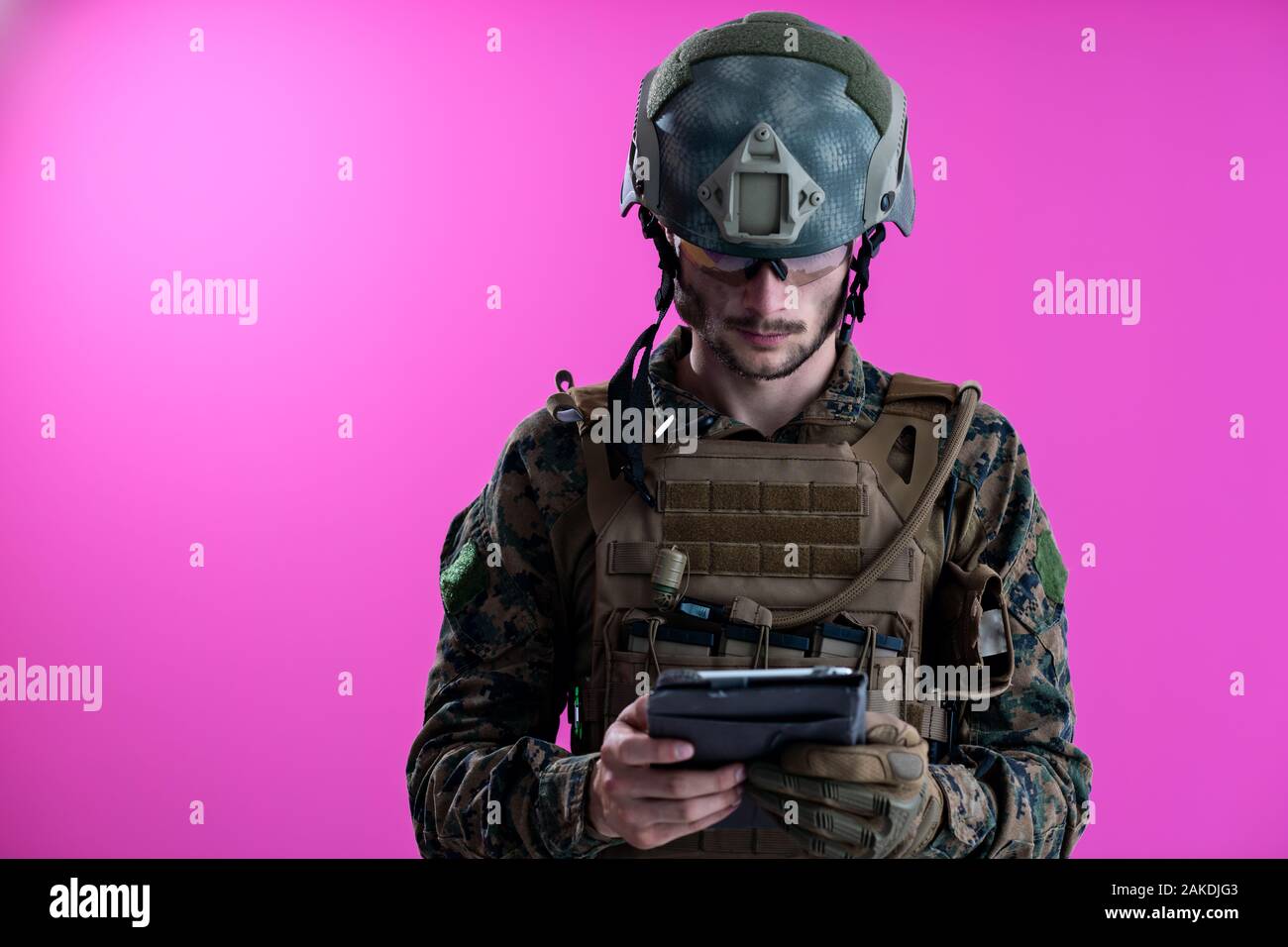 soldier using tablet computer hands closeup pnk background Stock Photo