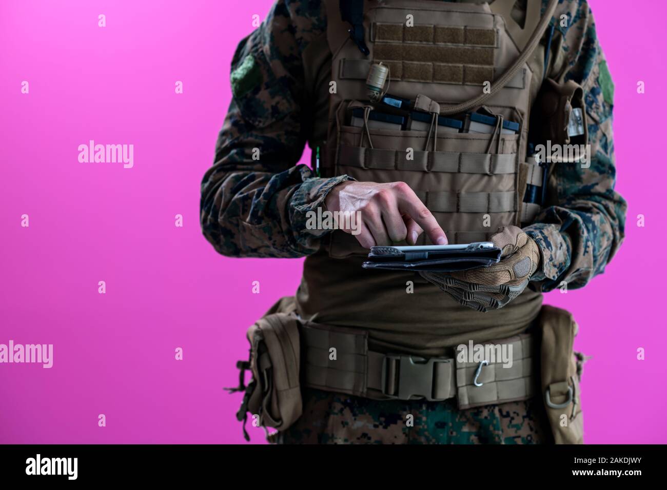soldier using tablet computer hands closeup pnk background Stock Photo