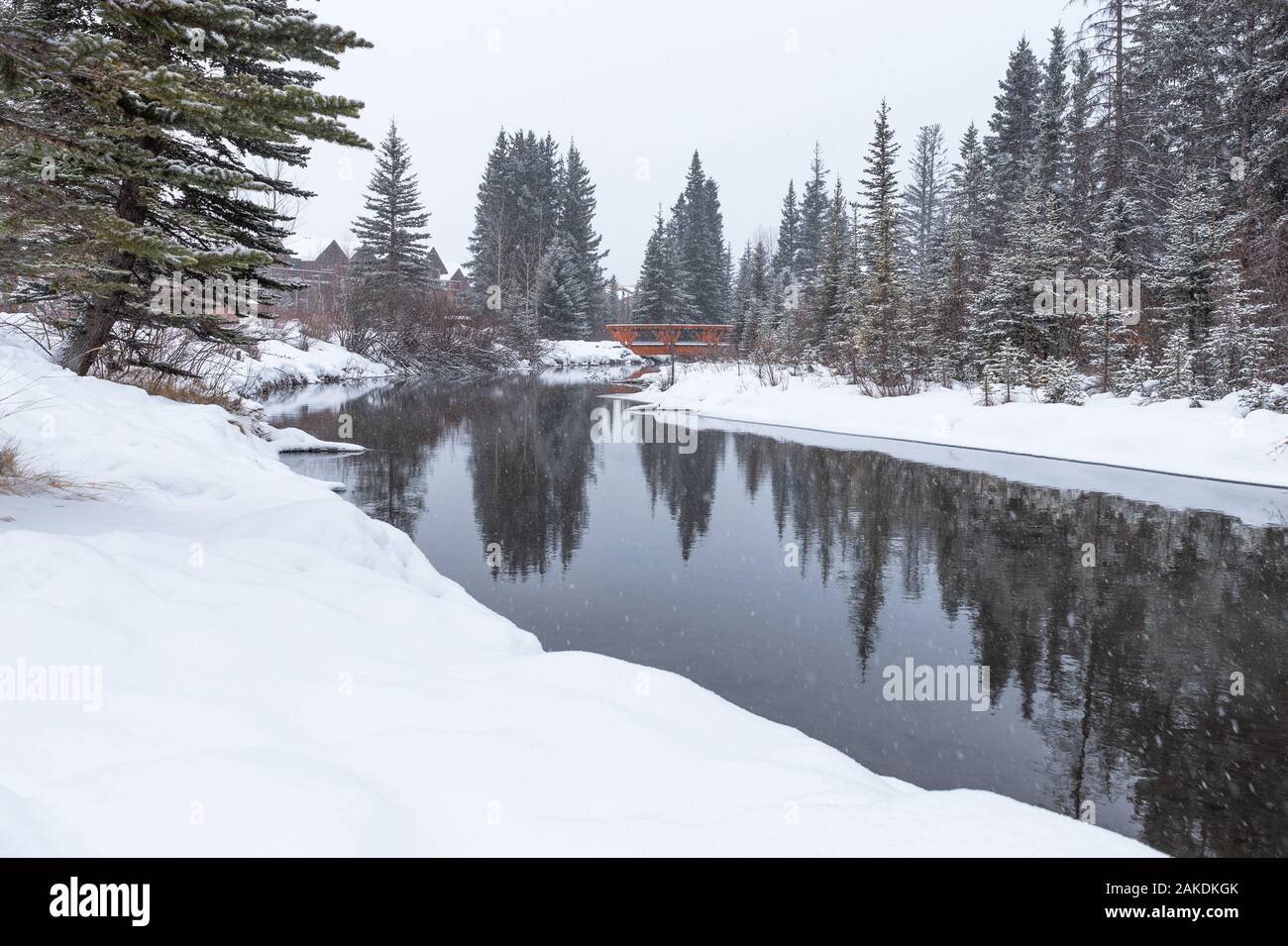 Snow falling on pedestrian bridge over Spring Creek in Canmore, Alberta, Canada Stock Photo