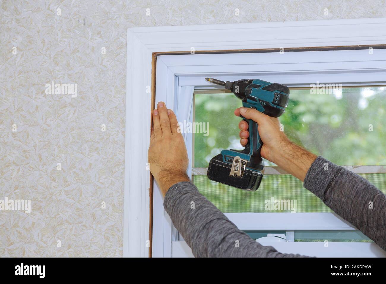 Process of worker installing new plastic pvc window man using a screwdriver Stock Photo
