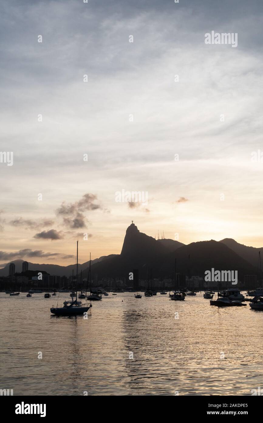 Sunset from Mureta da Urca in Rio de Janeiro, over the mountains and Christ the Redeemer Statue. Stock Photo