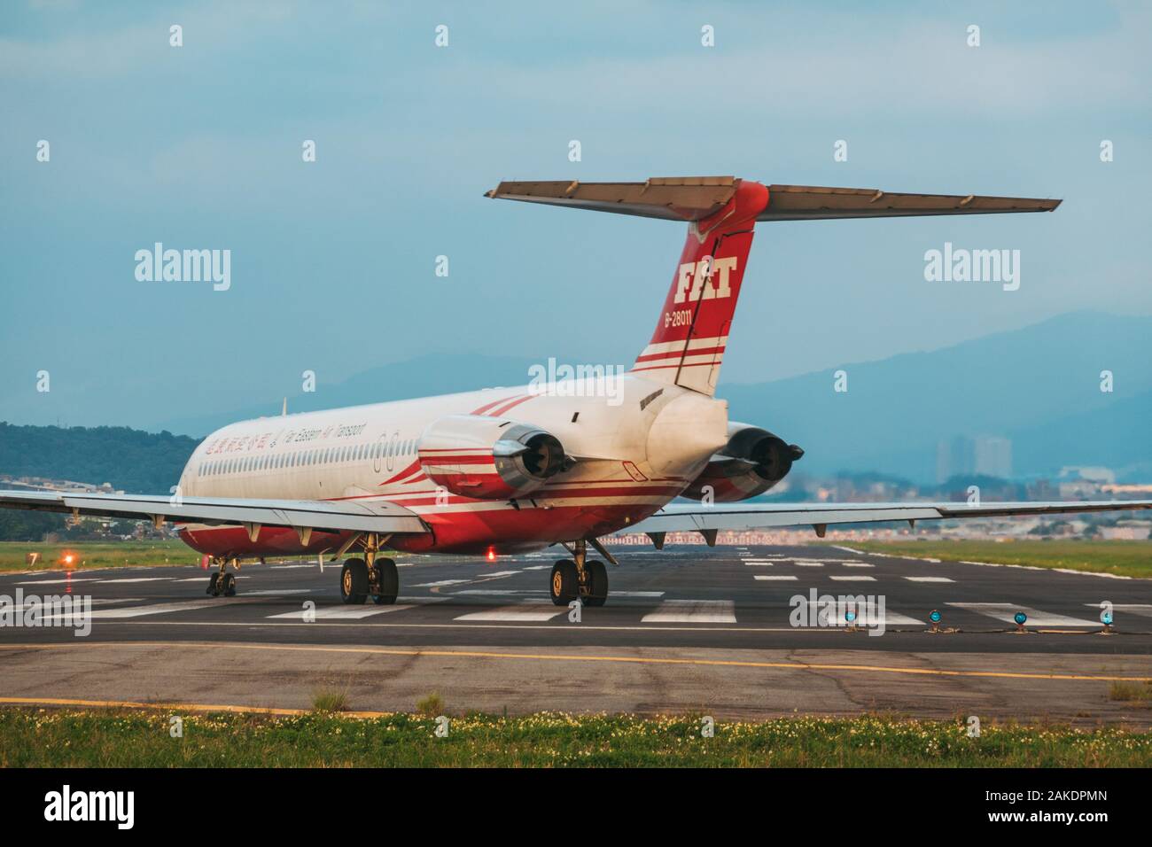 A McDonnell Douglas MD-83, of the now-defunct Far Eastern Air Transport, lines up for takeoff on Songshan Airport's runway one evening Stock Photo