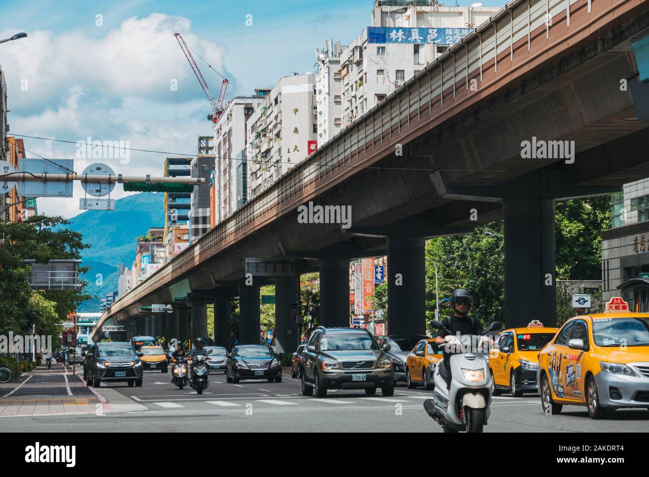 Traffic drives parallel to an elevated section of track on Taipei Metro near Daan Station Stock Photo