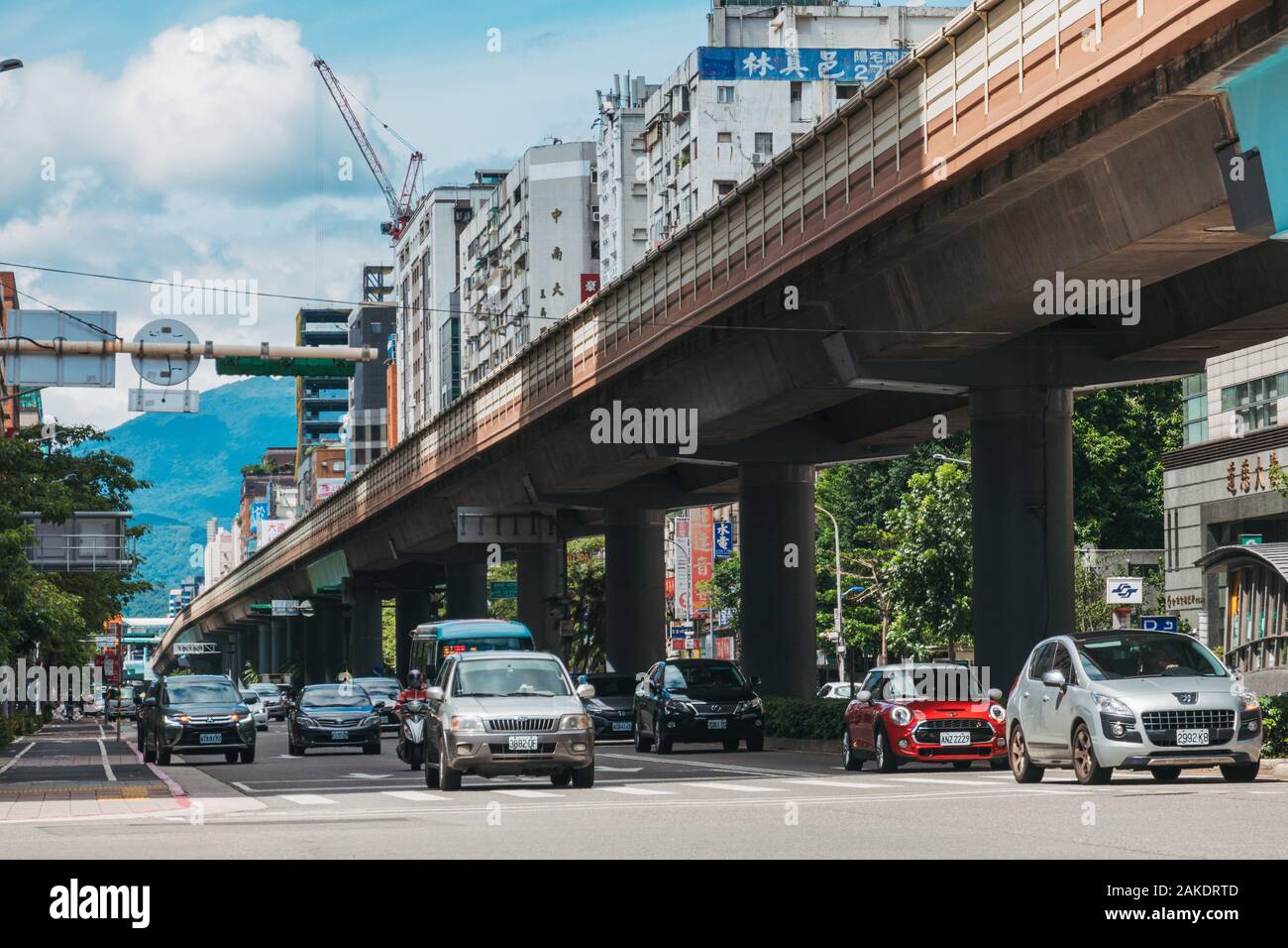 Traffic drives parallel to an elevated section of track on Taipei Metro near Daan Station Stock Photo