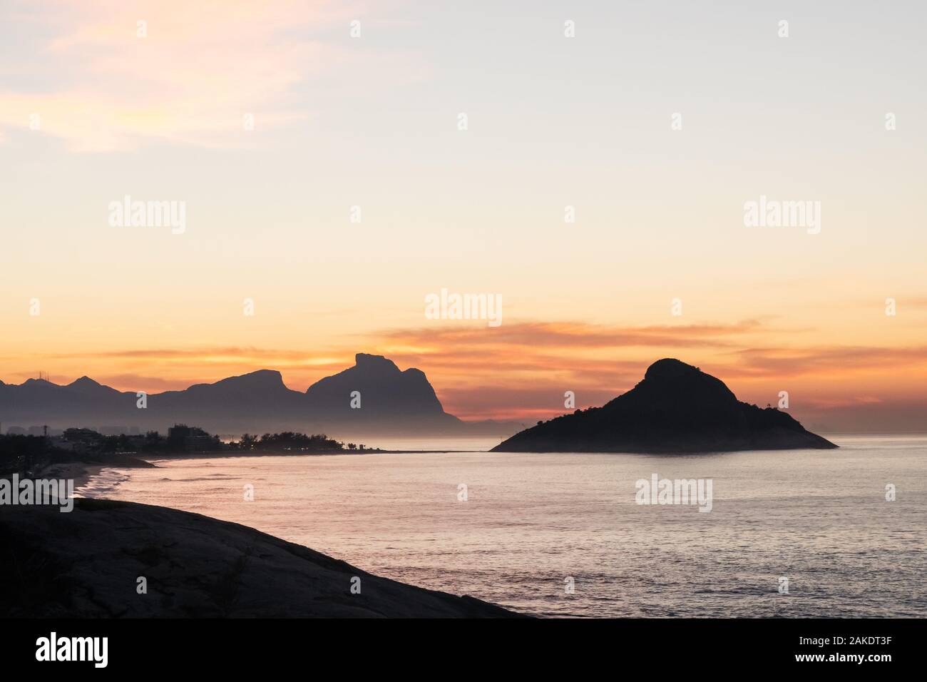 Golden dawn sunrise from Mirante do Roncador over Recreio Beach and the mountains of Rio de Janeiro. Stock Photo
