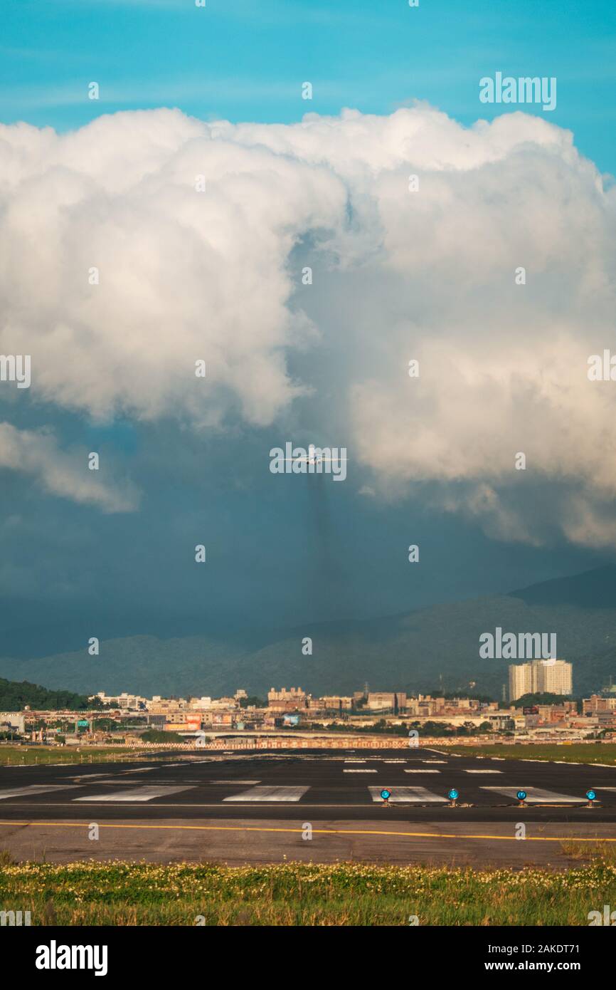 A McDonnell Douglas MD-80 of now-defunct Far Eastern Air Transport blasts off toward some cumulonimbus cloud, from Songshan Airport Stock Photo