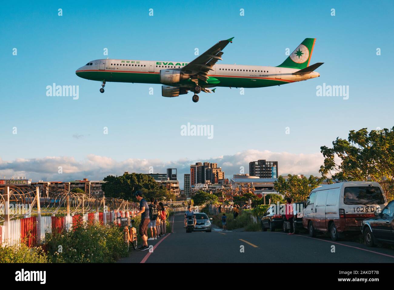 An EVA Airways Airbus A321 floats over the road on approach to Songshan Airport, Taipei. Stock Photo