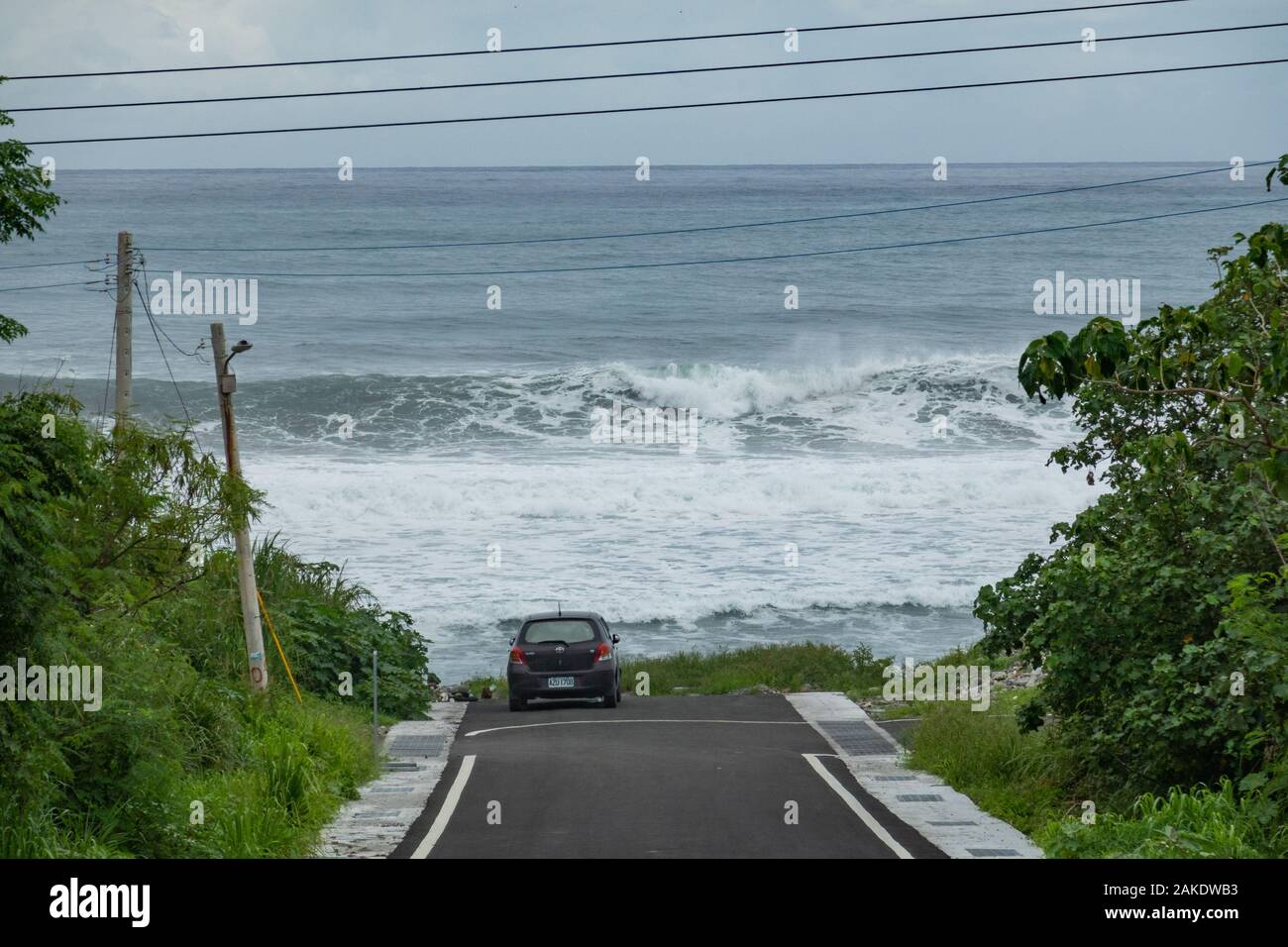 Big waves break in front of a parked car near Dulan Beach, in southern Taiwan, after a cyclone passed by Stock Photo