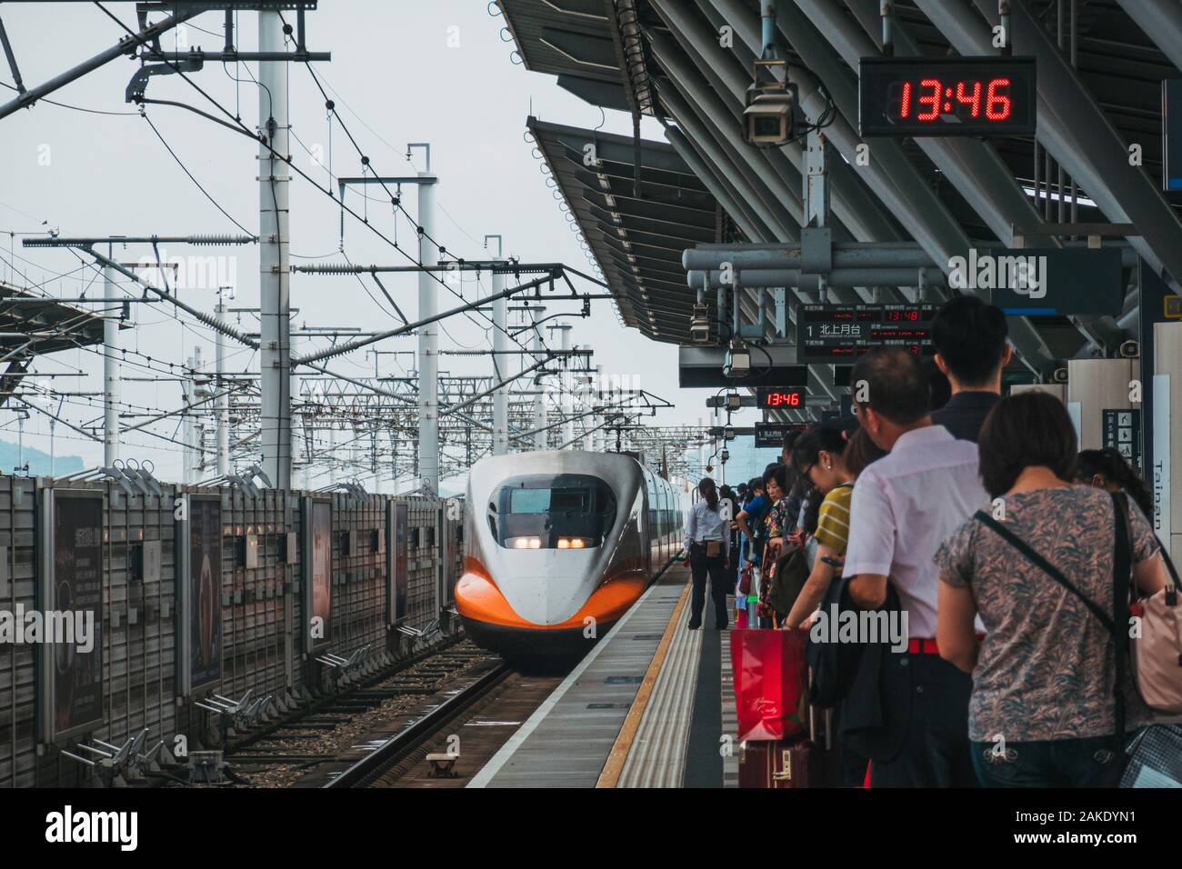 Passengers wait on the platform as a Taiwan High Speed Rail bullet train arrives at Tainan HSR station, Taiwan Stock Photo