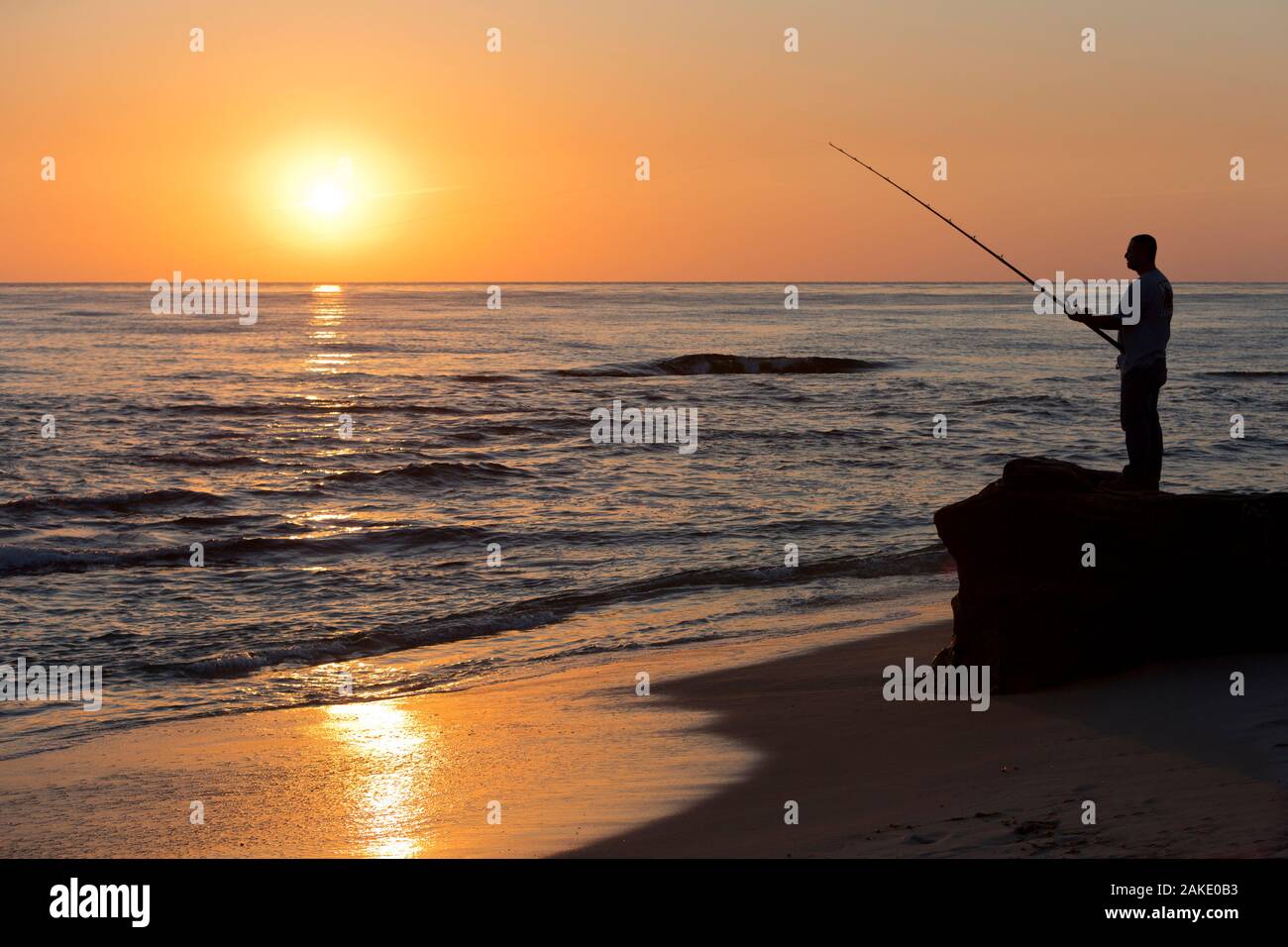 Man Surf Fishing at Sunset, La Jolla, California Stock Photo