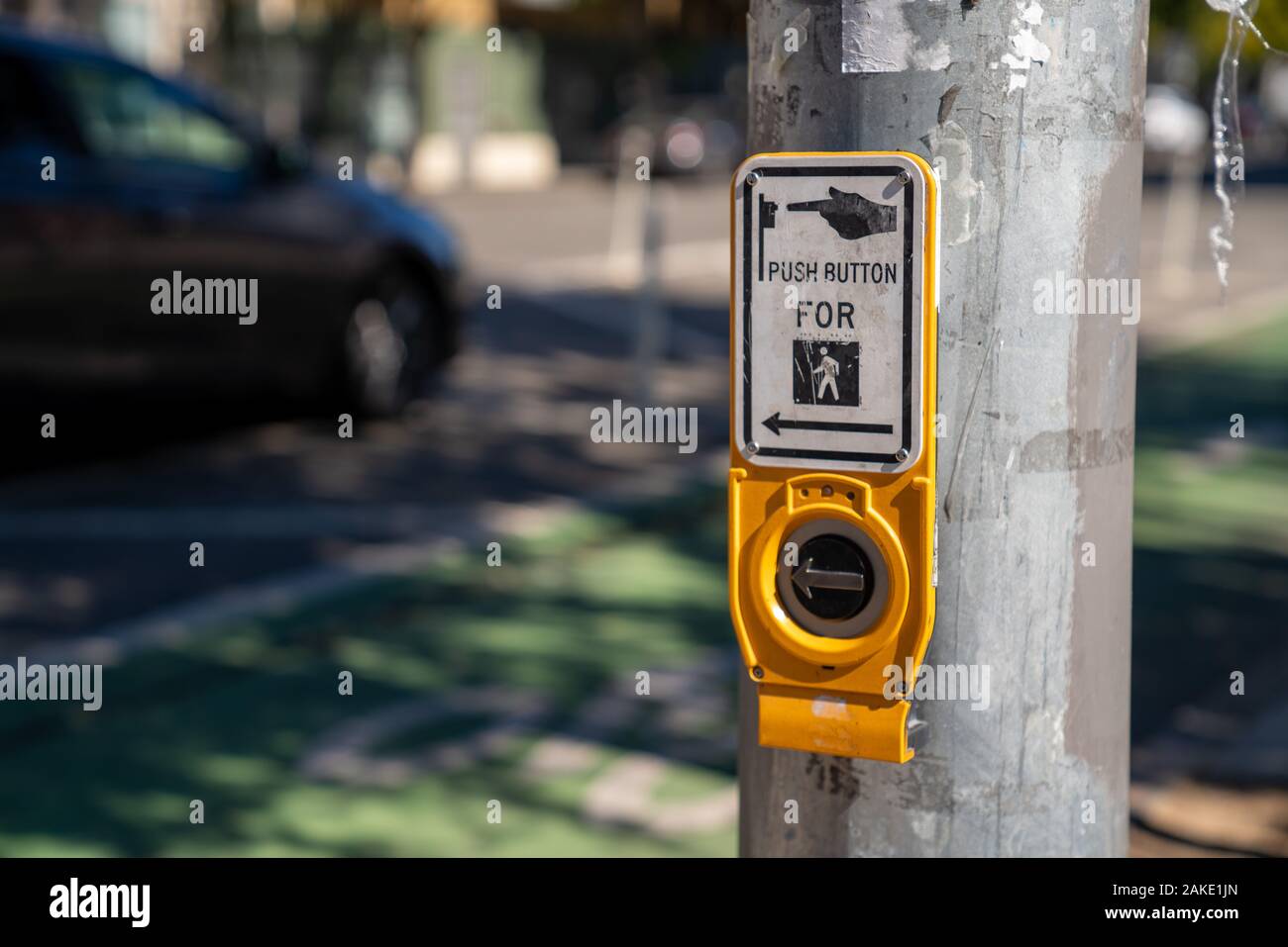 Push button cross walk intersection on light post with sign Stock Photo