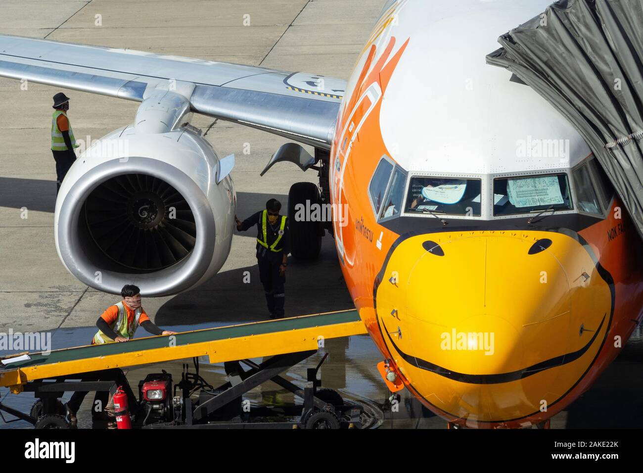 Bangkok, Thailand - December 5, 2019 : ground crew workers checking aircraft turbine engine, air intake and bag conveyor belt of Nok Air airplane befo Stock Photo