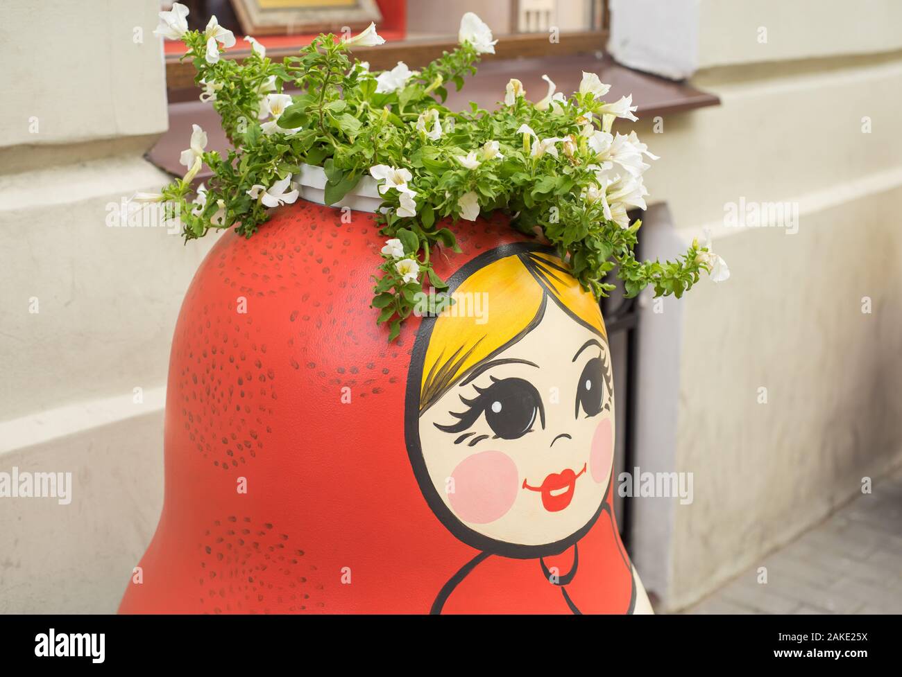 Russian traditional wooden doll matreshka decorated with painted flowers and patterns standing on the street of Saint-Petersburg. Stock Photo