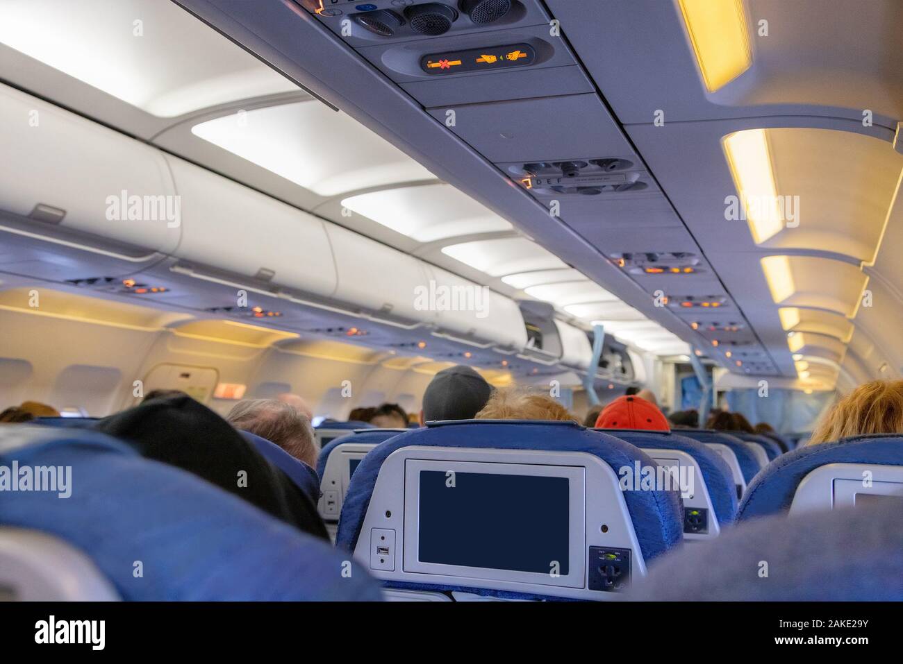 Inside of an airplane cabin with passengers on flight waiting for takeoff. Stock Photo