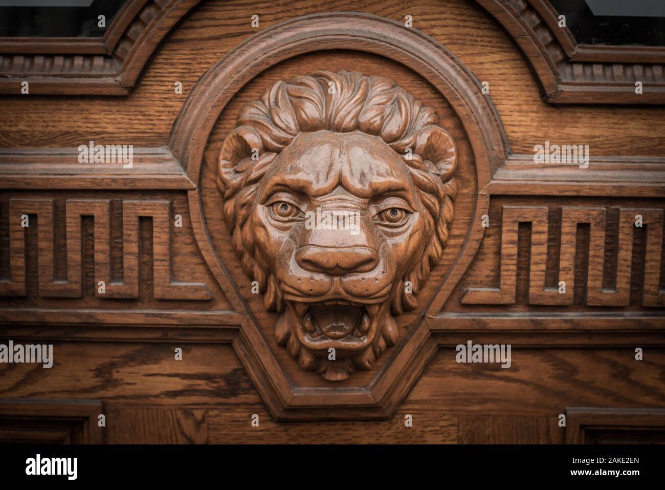 Big wooden head of lion on the front door. Stock Photo