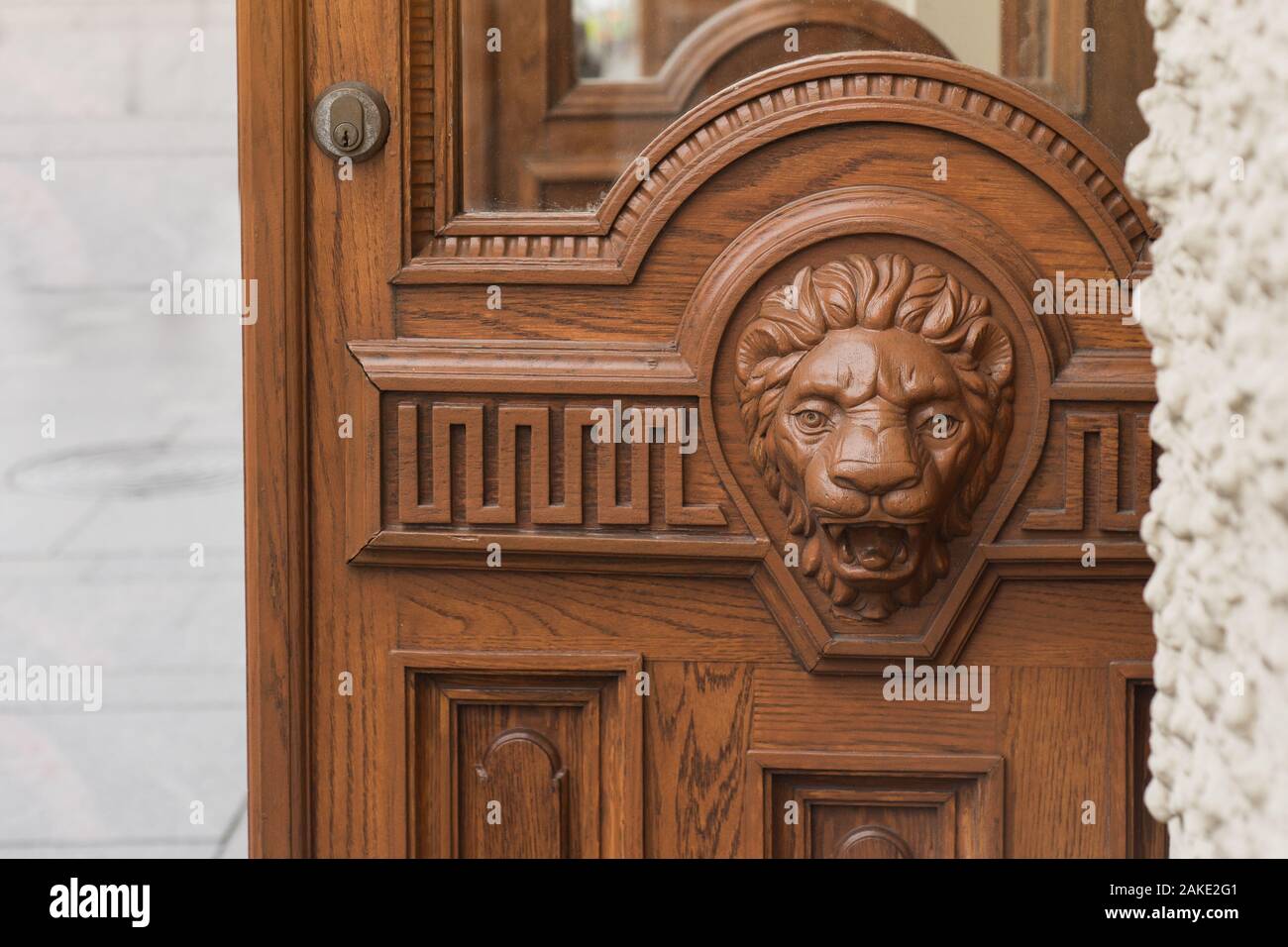 Big wooden head of lion on the front door. Stock Photo