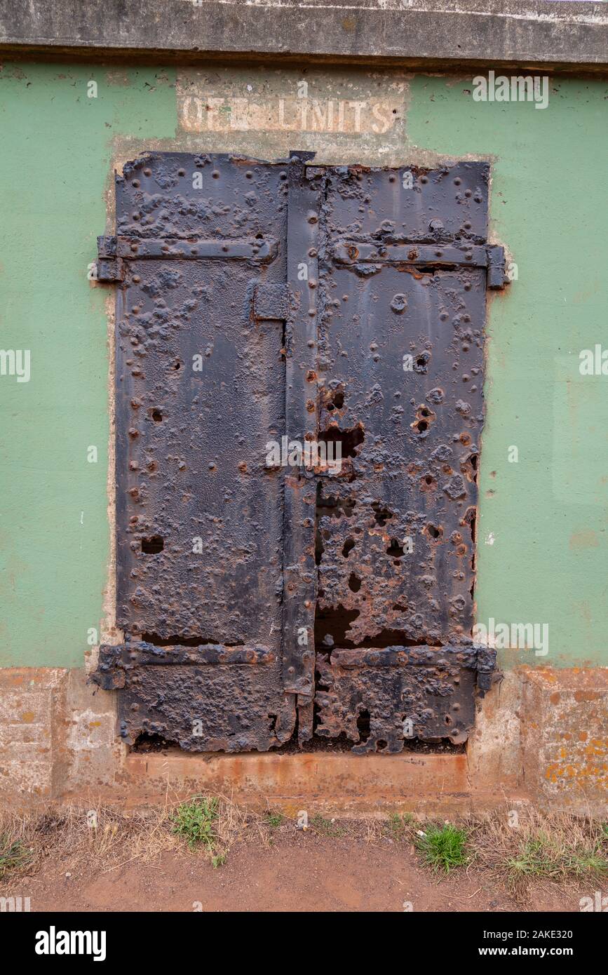 Tall steel metal door labeled off limits eroded from rust and elements warning off limits Stock Photo