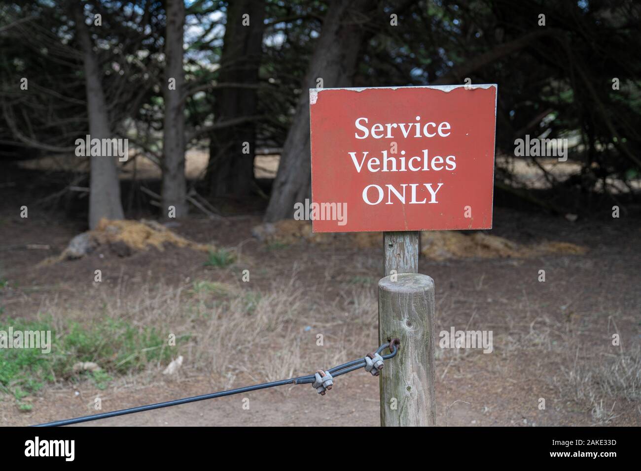 Service vehicles only sign on wooden post in front of woodlands Stock Photo