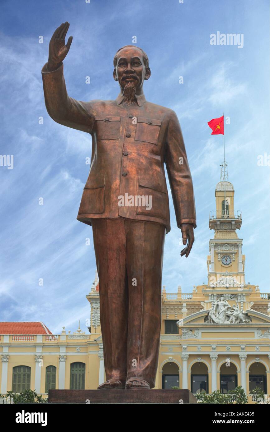 Statue of Ho Chi Minh with vietnamese flag in the background, in front of Saigon City Hall, Vietnam. Stock Photo