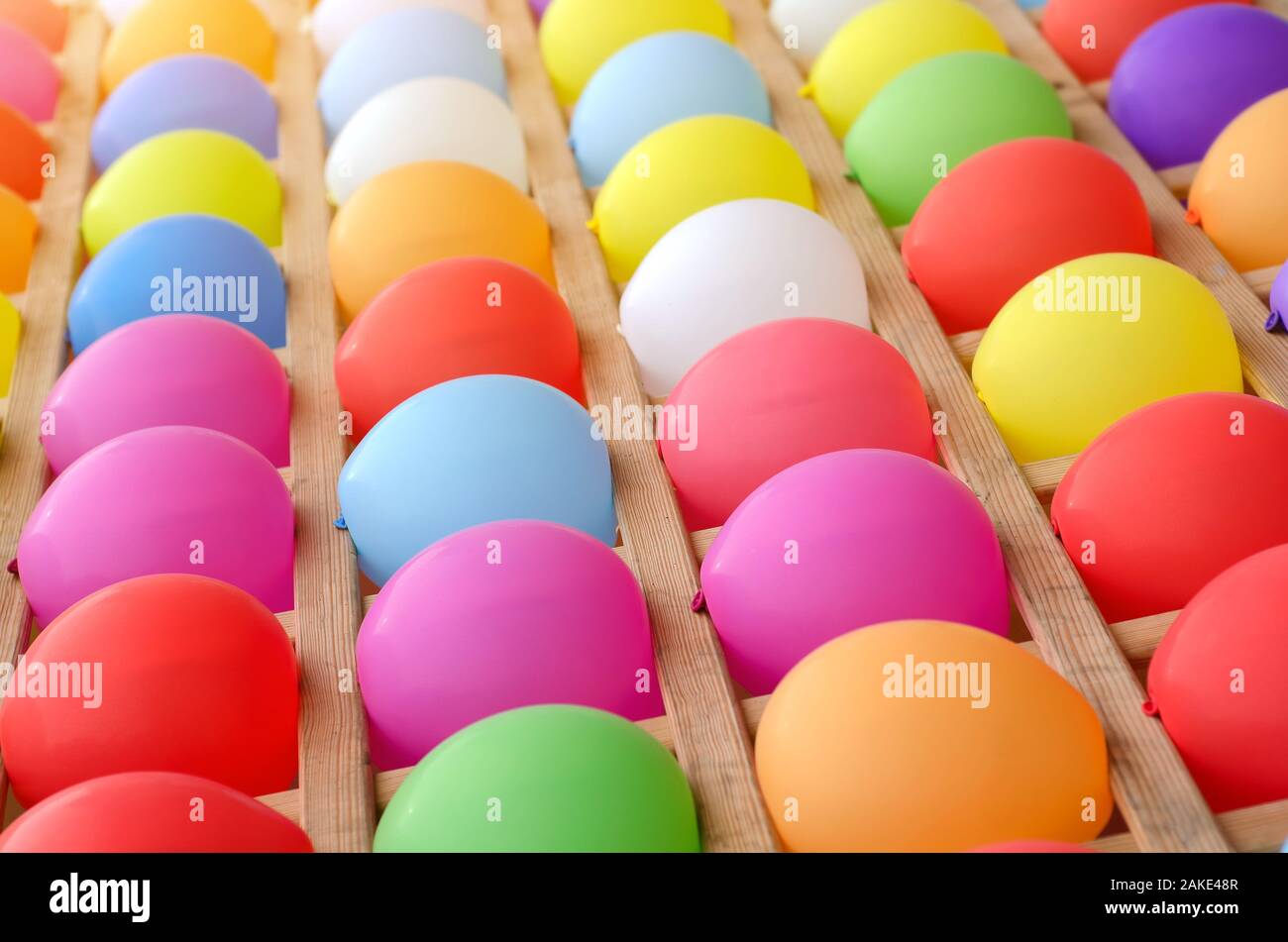 Colorful balloons as targets. Wall of colored balloons with some popped, carnival game. Stock Photo