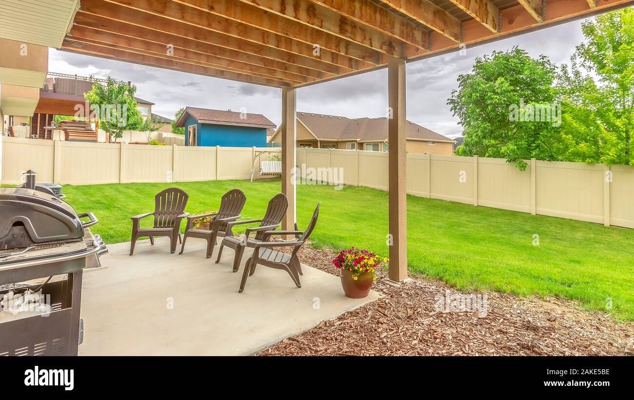 krak filosofisk Lavet af Panorama Patio at the backyard of a home with roof columns chairs and  barbecue grill Stock Photo - Alamy
