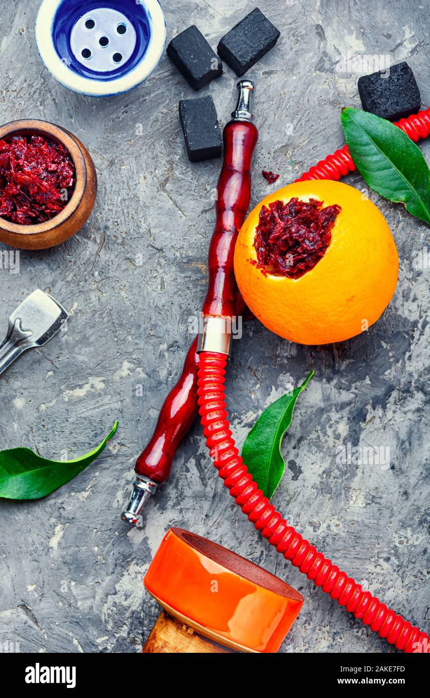 Smoking hookah pipe with mouthpiece and citrus flavored shisha tobacco