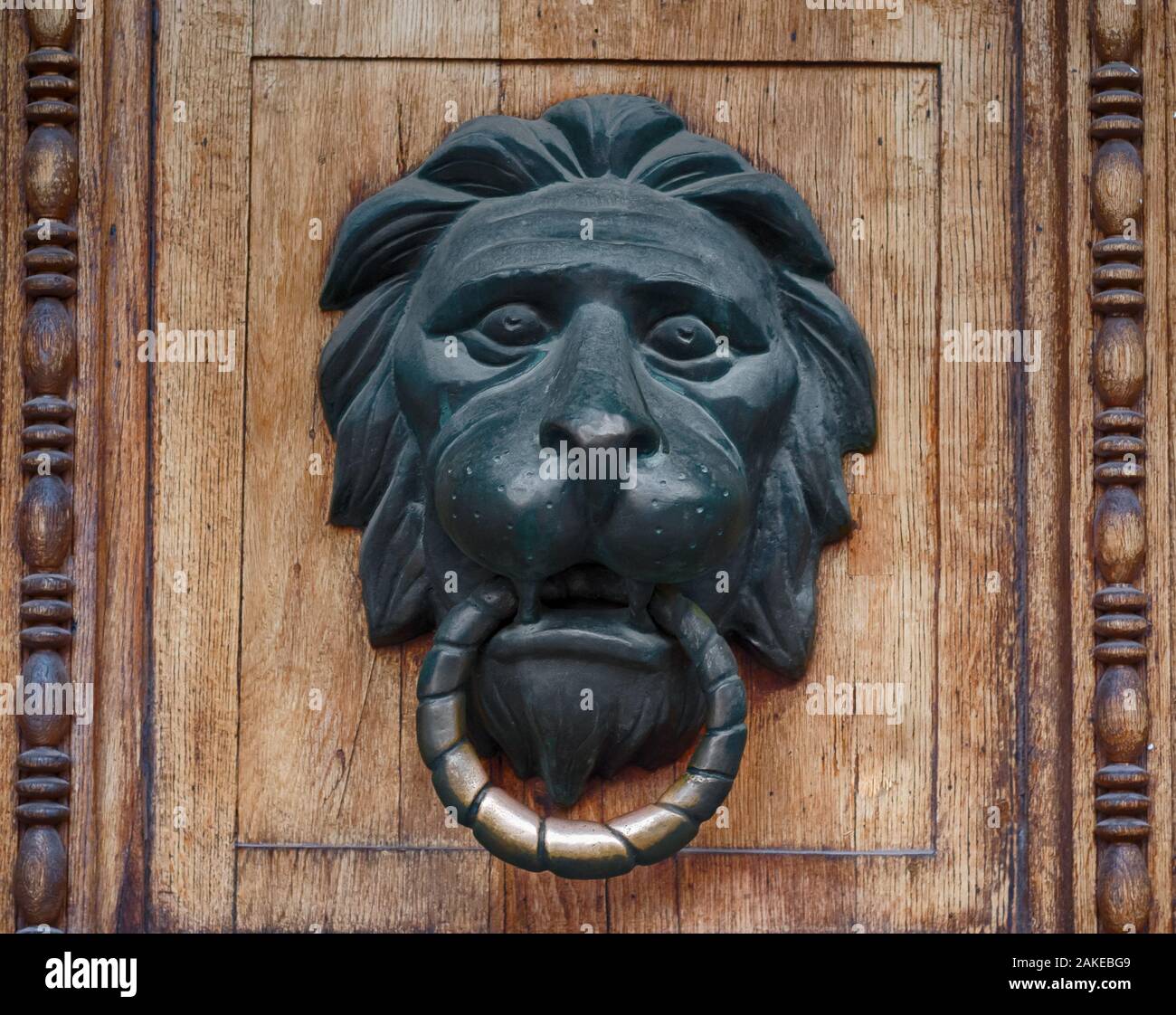 Door handle in the form of a bronze lion's head with a ring Stock Photo