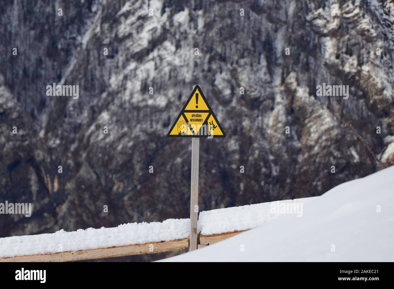 Sign warning of the danger of falling from a cliff edge at Vogel Ski Resort, Triglav National Park, Slovenia Stock Photo