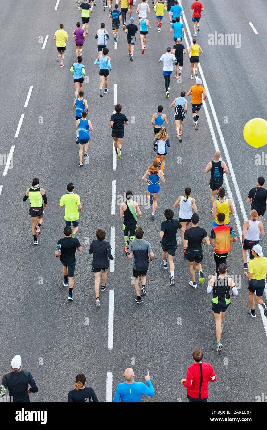 Runners on the street. Athletes in motion. Urban competition. Vertical ...