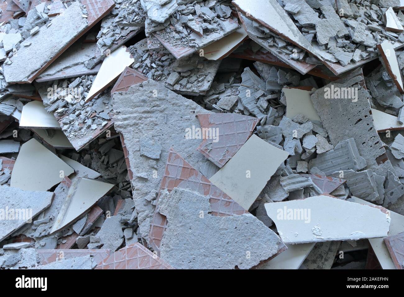 Closeup discarded pile of rubble mainly consists of pieces of broken tiles, thrown away at construction site during repair and renovation process Stock Photo
